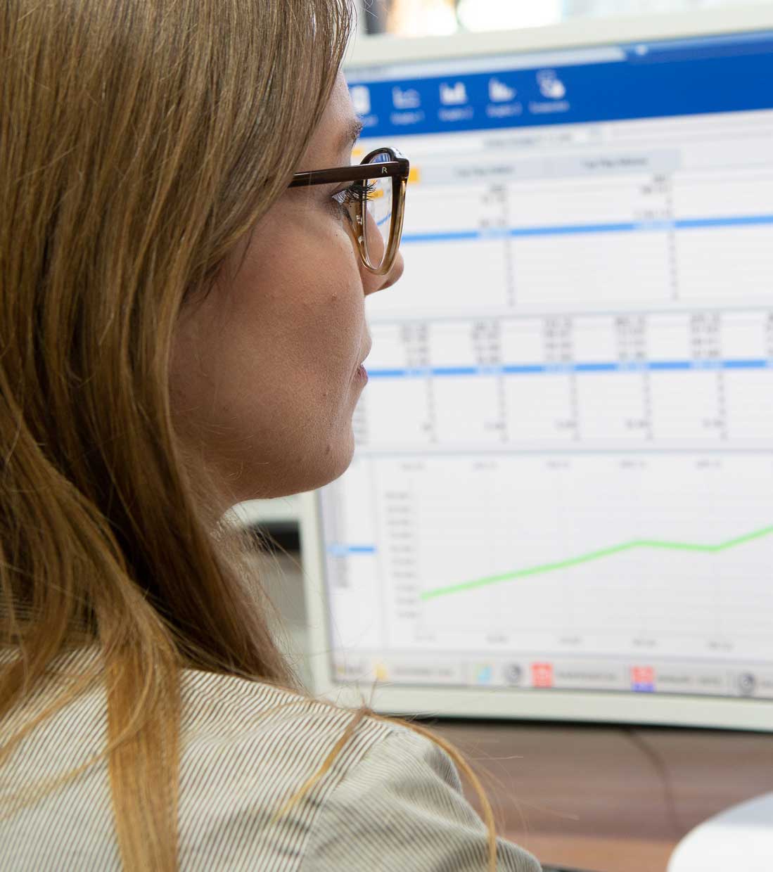 Frau vor Bildschirm mit Tabelle und statistischer Auswertung